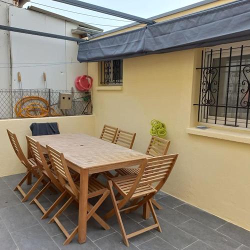 une table et des chaises en bois sur une terrasse dans l'établissement Barcarès village - plage - mer - 4/9p+cour 3 étoil, au Barcarès