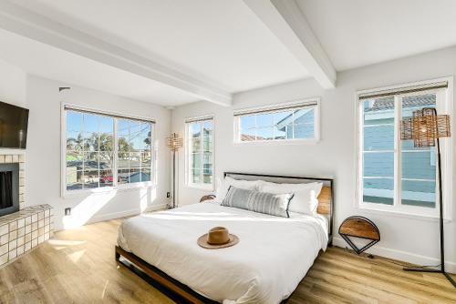 un dormitorio blanco con una cama con sombrero en Ormond Retreat w Ocean View, Steps2beach & Garage, en San Diego