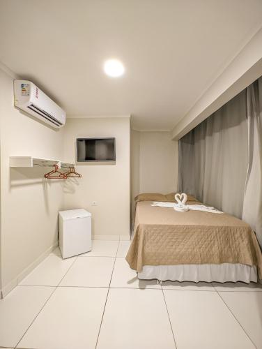 a bedroom with a bed and a tv in it at Pousada do Alemão in Maragogi