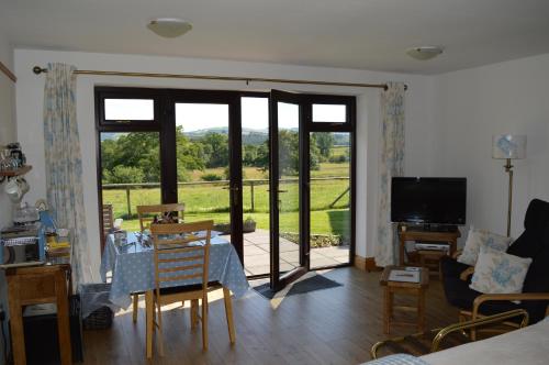 a living room with sliding glass doors and a table and chairs at Smithfield Farm Bed & Breakfast in Builth Wells