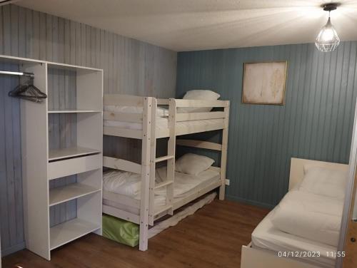 a room with two bunk beds and a couch at Proches des pistes F2 36m2 4-6 pers 2 étoiles in Besse-et-Saint-Anastaise