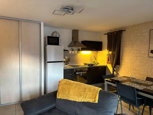 un salon avec un canapé et une cuisine dans l'établissement RAVISSANT APPARTEMENT, à Briançon