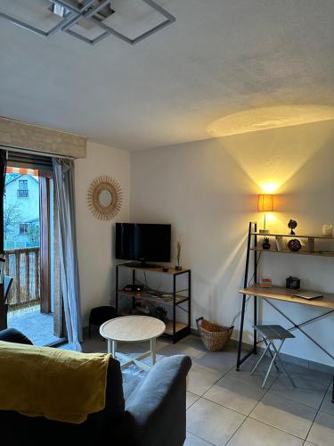 un salon avec un canapé et une table dans l'établissement RAVISSANT APPARTEMENT, à Briançon