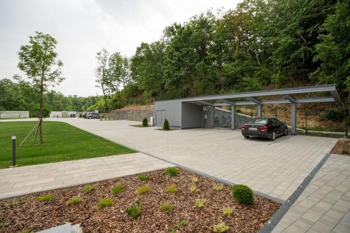 a car parked in a parking lot with a garage at Gátőr Villa in Mőcsény