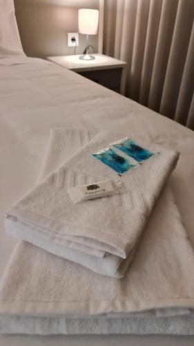 uma cama branca com toalhas brancas em Up Sal em Aveiro