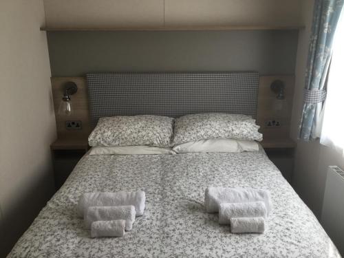ein Bett mit zwei Handtüchern darüber in der Unterkunft Lakeside Holiday Home in Hastings
