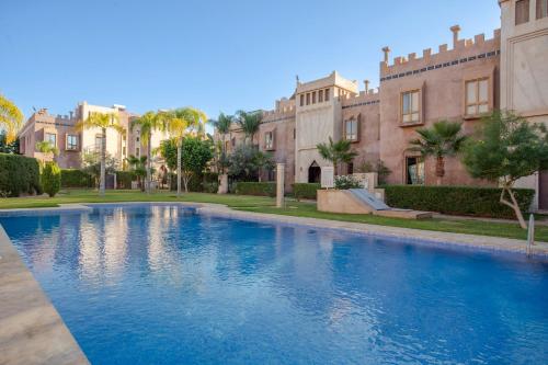 a swimming pool in front of a building at Riad Azia in Marrakesh