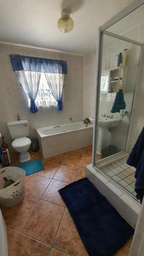 ein Bad mit einer Badewanne, einem WC und einer Dusche in der Unterkunft Tiny's Getaway in Jeffreys Bay