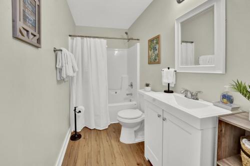 a white bathroom with a toilet and a sink at Bahama Breeze Suites in Panama City Beach