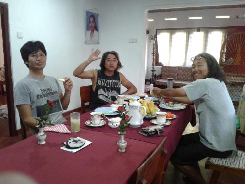 un grupo de personas sentadas alrededor de una mesa en Surf reef guest house, en Mirissa