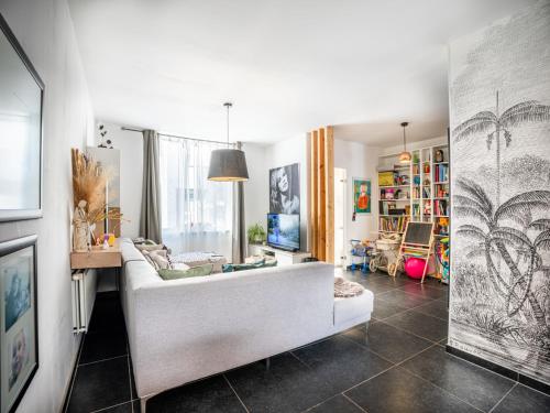 a living room with a white couch and a table at Casa Julie in De Panne