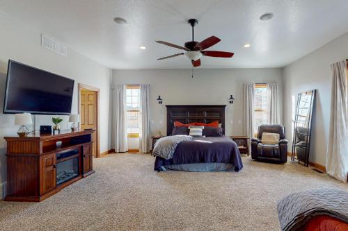 a bedroom with a bed and a flat screen tv at High Country Pool House in Sturgis