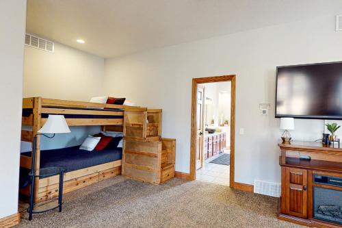 a bedroom with bunk beds and a flat screen tv at High Country Pool House in Sturgis