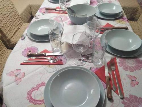 a table with plates and wine glasses on a table at Lovely studio in Dragoman with garden and garage in Dragoman