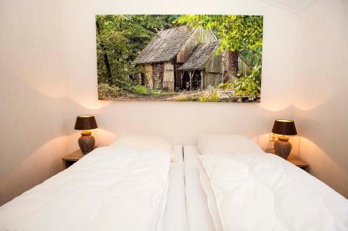 two beds in a room with a picture of an old barn at Brunninkhuizerbeek in Hezingen
