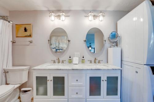 a bathroom with a sink and a toilet and mirrors at Bayfront Paradise - Flexible 30 Day plus w Amazing Bay View and Pool in San Diego