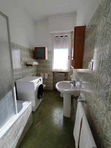 a bathroom with a sink and a washing machine at casa di Baia in Pesaro