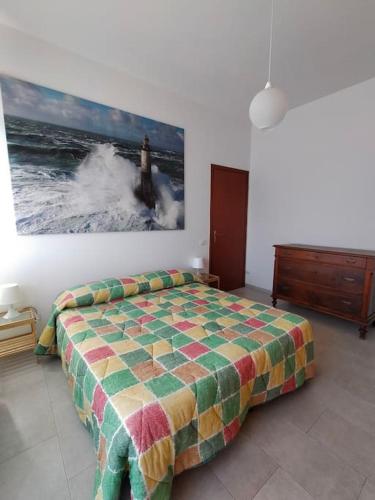 a bedroom with a bed and a painting on the wall at casa di Baia in Pesaro