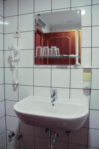a bathroom with a white sink and a mirror at Hotel Kamanga in Tomar
