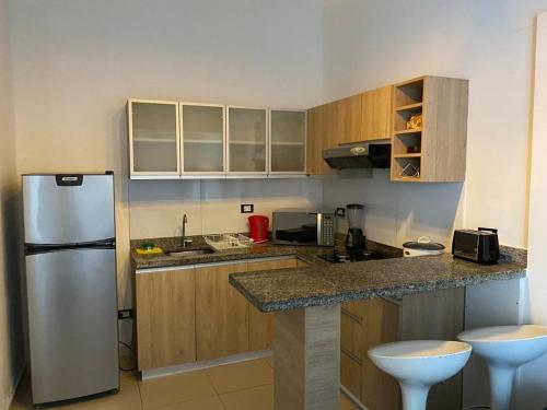 cocina con armarios de madera y nevera de acero inoxidable en Luxury Apartments Lima, en Lima