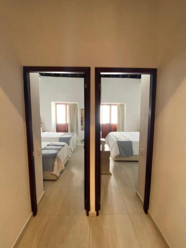 a room with two beds and two mirrors at Hotel Casa Agustina in Cartagena de Indias