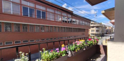 a balcony with flowers on a brick building at Hakuna Matata in Cuenca