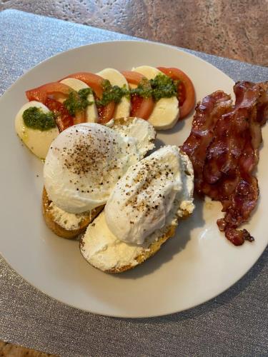 een bord met eieren, spek en tomaten bij Arce Boutique in Braşov