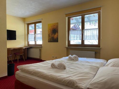 ein Schlafzimmer mit einem Bett mit zwei Handtüchern darauf in der Unterkunft Landhotel Alte Post in Oberstaufen