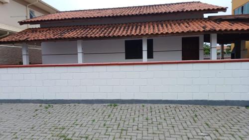 un bâtiment avec un toit en carrelage et une allée en briques dans l'établissement Casa na praia do Sonho, à Palhoça