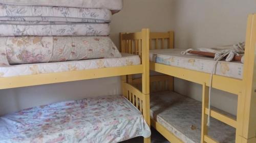 Ce lit superposé se trouve dans un dortoir doté d'un petit lit. dans l'établissement Casa na praia do Sonho, à Palhoça