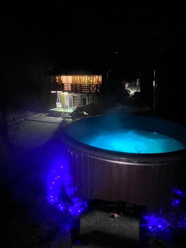 a hot tub with blue lights in the dark at Dva Braty eco in Podobovets