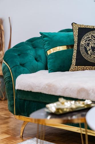 a green couch with a plate on a coffee table at Apartman Princip in Pale