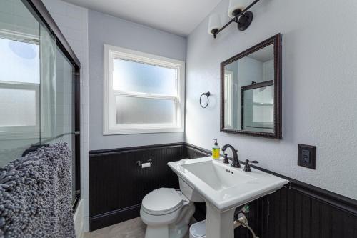 a bathroom with a sink and a toilet and a mirror at Bungalow Oasis in Concord