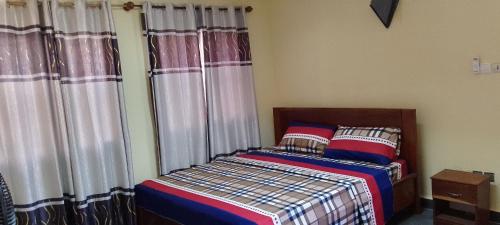 a bedroom with a bed with curtains and a bed sidx sidx sidx sidx at ADISSA in Cotonou