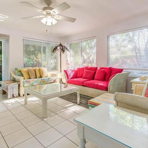 a living room with a red couch and a table at Little Bay Compound in Islamorada