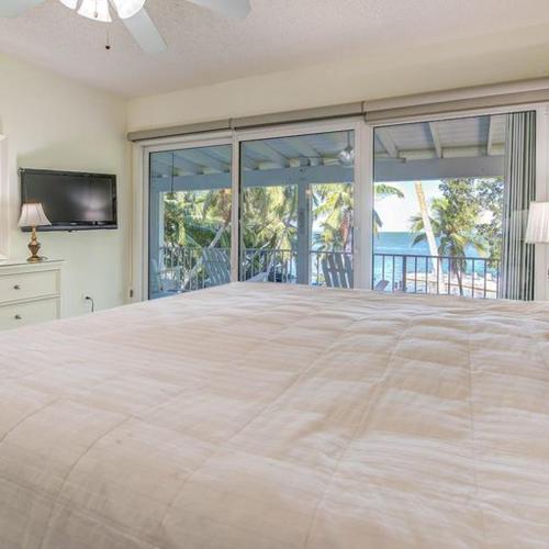 a large bedroom with a large bed and a television at Little Bay Compound in Islamorada