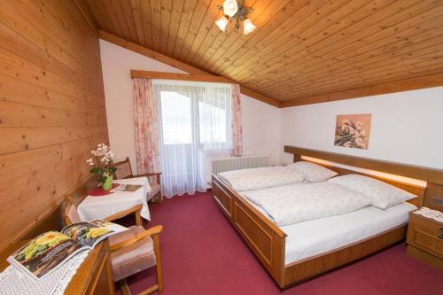 a bedroom with two beds in a wooden room at Pension Bergblick in Kaprun