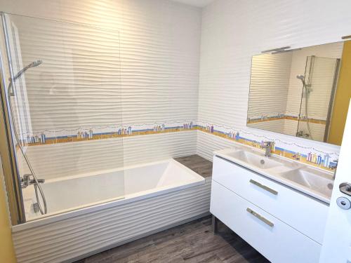 une salle de bain blanche avec une baignoire et un lavabo dans l'établissement Port Jure Face a la mer, à Les Sables-dʼOlonne