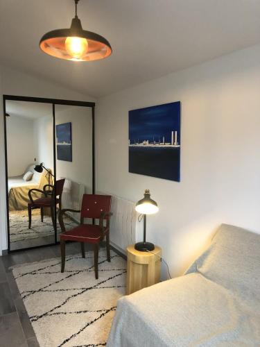 une chambre avec un lit, une chaise et une table dans l'établissement BIG BEN 750m de la Plage, à Les Sables-dʼOlonne