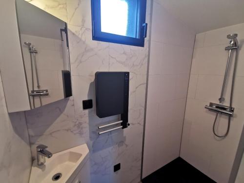 une salle de bain avec un lavabo et une douche avec une fenêtre dans l'établissement BIG BEN 750m de la Plage, à Les Sables-dʼOlonne