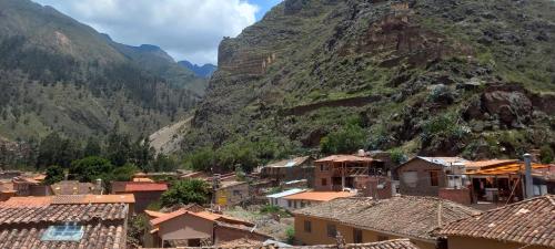 un village en face d'une montagne dans l'établissement Hostal Raymi, à Ollantaytambo