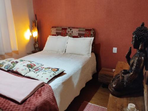 a bedroom with a bed and a statue next to it at Pousada Avambaé in São Miguel das Missões