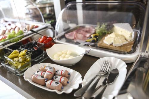 a buffet with food on a counter with plates and utensils at Hotel Marienthal Garni in Hamburg