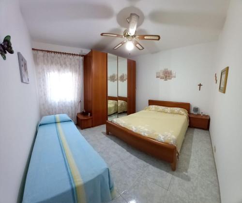 a bedroom with a bed and a ceiling fan at Casa Vacanza Lidoconchiglie in Lido Conchiglia