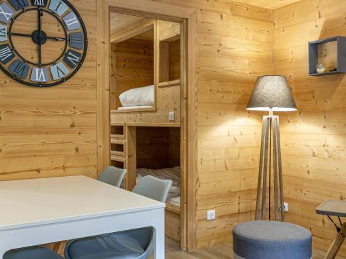 Cette chambre dispose d'une table, d'une horloge et de lits superposés. dans l'établissement Appartement chaleureux avec parking à La Clusaz - FR-1-437-68, à La Clusaz