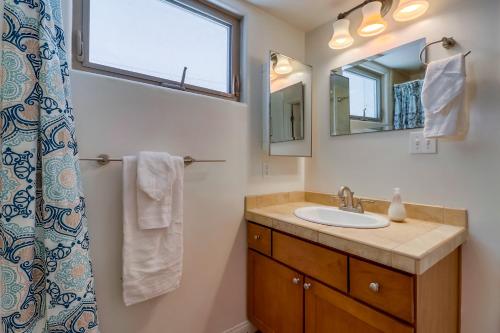 a bathroom with a sink and a mirror at Beach Oasis - Rooftop, Steps2Sand and Water Views in San Diego