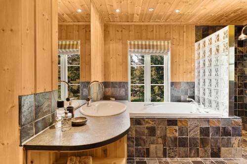 a large bathroom with a tub and a sink at Spektakulær hytte med fantastisk utsikt in Strande
