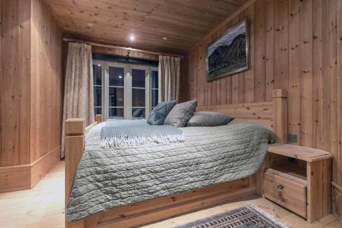 um quarto com uma cama num quarto de madeira em Spektakulær hytte med fantastisk utsikt em Strande