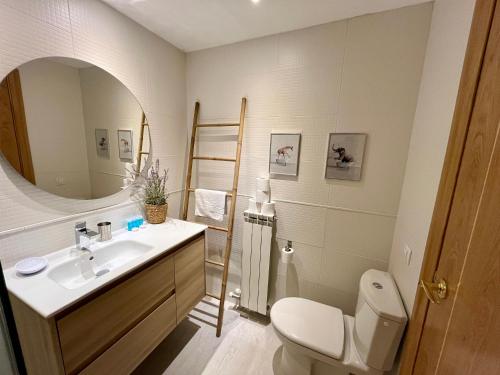 a bathroom with a sink and a toilet and a mirror at C15 - Apartamento gran terraza Aigualluts - Villmor in Cerler