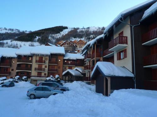 un parking couvert de neige à côté des bâtiments dans l'établissement Studio Cabine 4/5 pers 2* avec Balcon Plein Sud et Parking - Centre de Valloire, Proche Remontée - FR-1-263-449, à Valloire